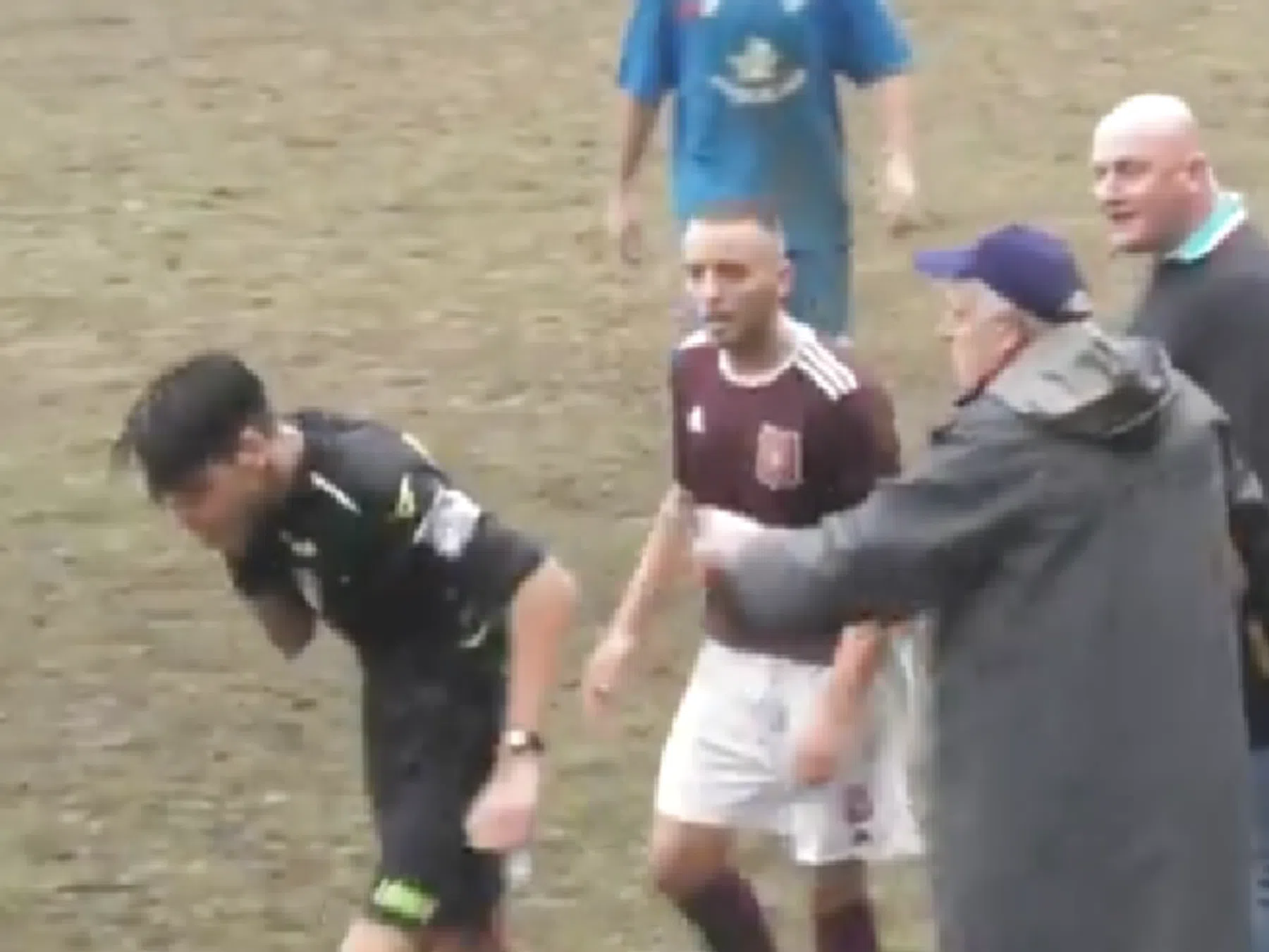 Scheidsrechter Andrea Felis (links) nadat hij een klap heeft gekregen van Giovanni Alosi (geheel rechts).